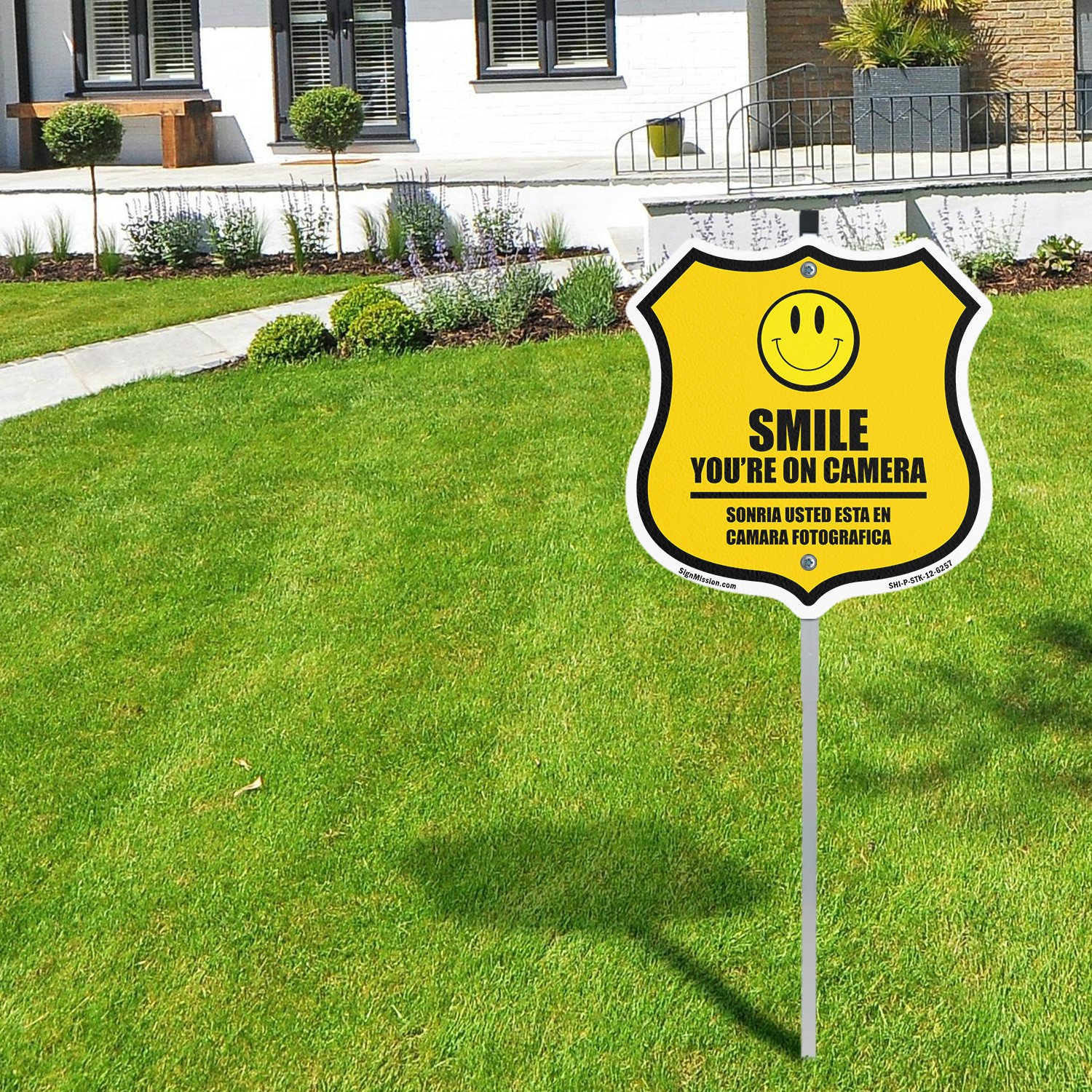 Smile You’re On Camera Bilingual English / Spanish Shield Shaped Sign With Stake
